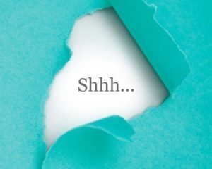 torn paper revealing the word shhh...