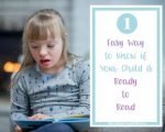 one way to know if your child is ready to read, girl looking at a book