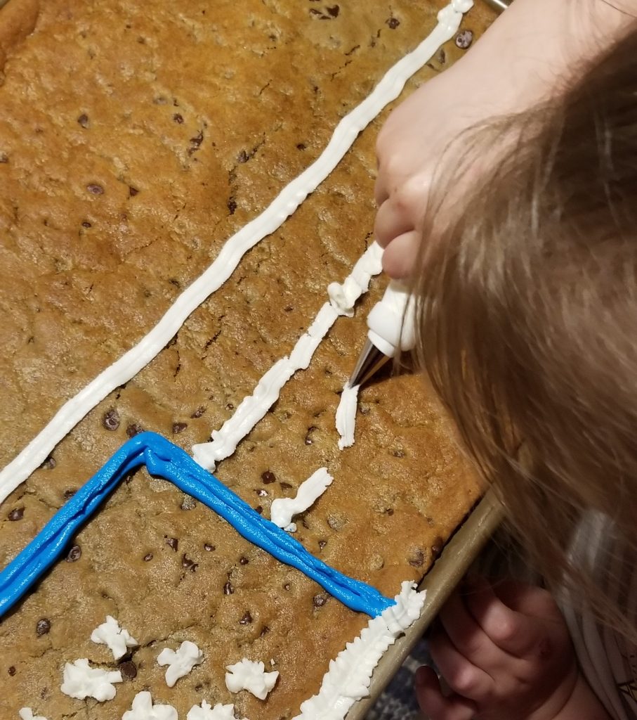 little girl icing easy cookie cake at home